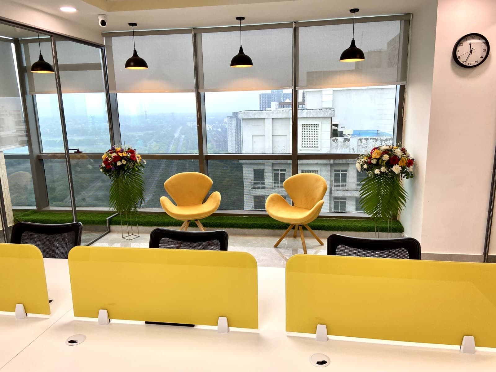 Bright lounge area with yellow seating overlooking the city from Dewberry Advisors office