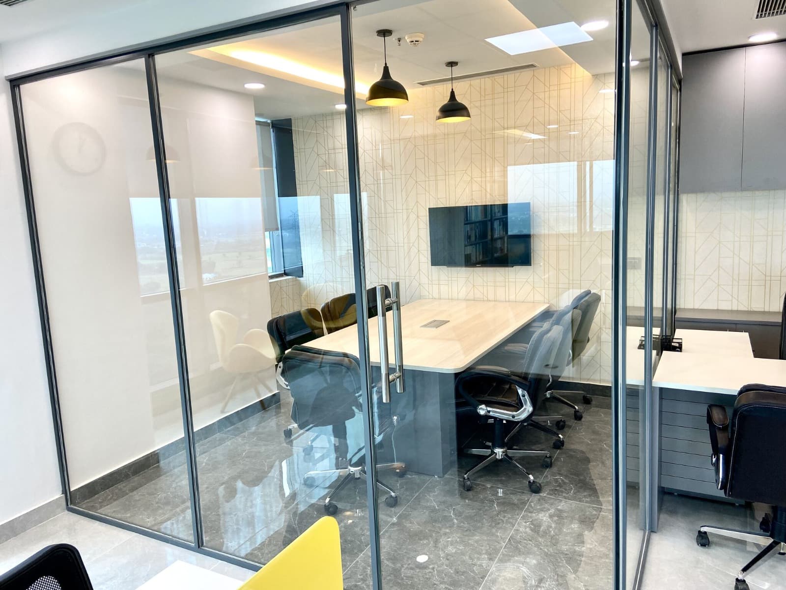Glass-walled meeting room with city views at Dewberry Advisors